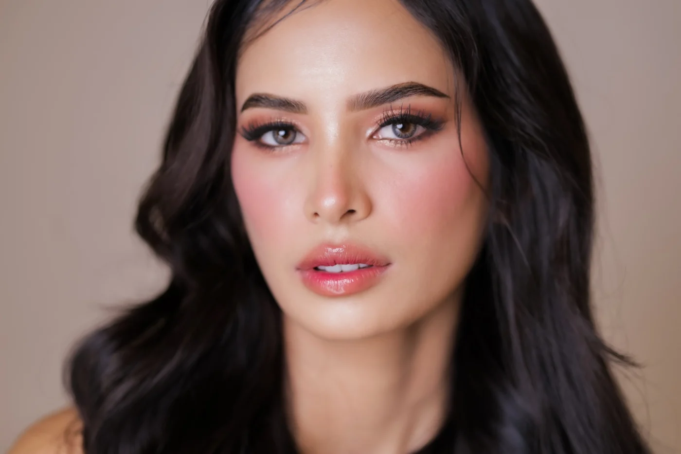 Beauty portrait with long dark waves, defined eye makeup and rosy pink lips and cheeks
